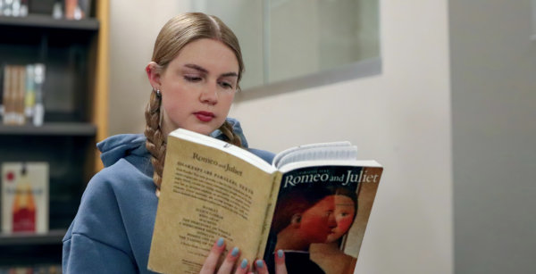 Kate Meis '25 reads Romeo and Juliet in the library.